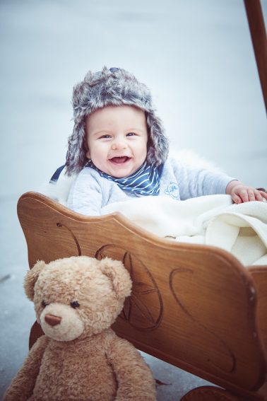 lachendes-Baby-am-See-Leiterwagen